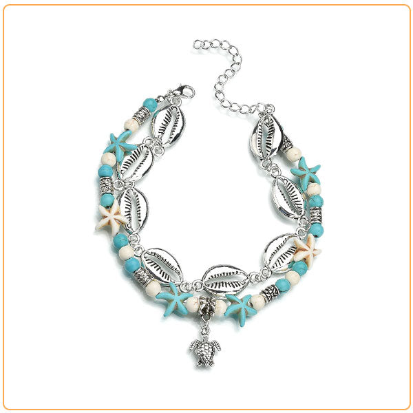 Bracelet de cheville en coquillages cauris étoiles de mer avec amulette tortue de mer sur fond blanc Kaosix