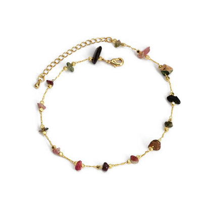 Bracelet de cheville en éclats de pierre de tourmaline et chaînette dorée sur fond blanc Kaosix