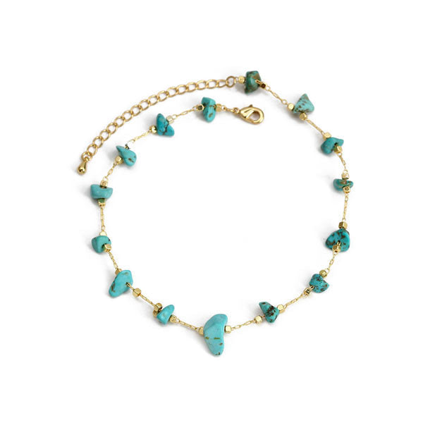 Bracelet de cheville en éclats de pierre turquoise et chaînette dorée sur fond blanc Kaosix