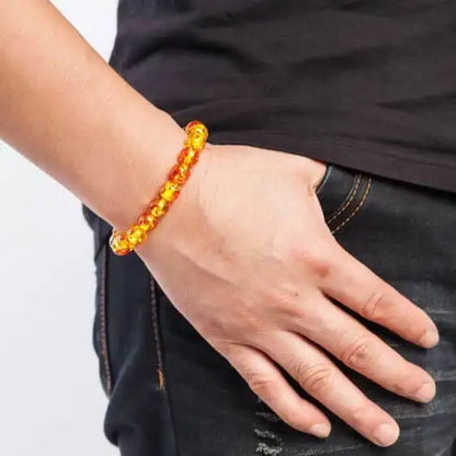 Bracelet en Perles d’Ambre Jaune au poignet d'un homme avec un t-shirt et un jeans noir Kaosix