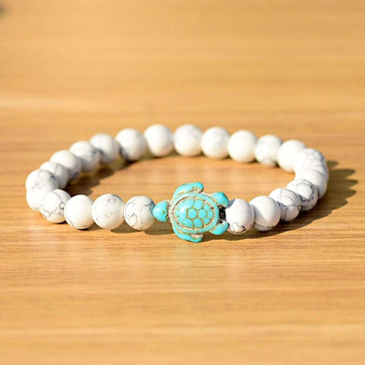 Bracelet howlite blanche Tortue Marine sur une planche de contre-plaqué clair Kaosix