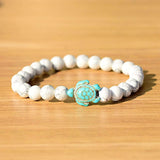 Bracelet howlite blanche Tortue Marine sur une planche de contre-plaqué clair Kaosix