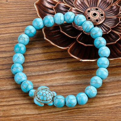 Bracelet pierre bleu turquoise tortue marine sur table en bois Kaosix