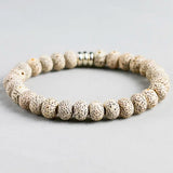 Bracelet tibétain graine de bodhi protection posé sur un sol gris Kaosix