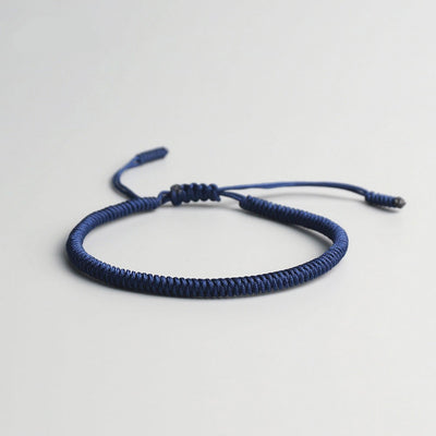 Bracelet tibétain porte-bonheur bleu sur sol gris Kaosix