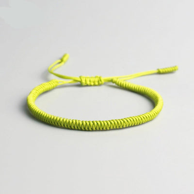 Bracelet tibétain porte-bonheur vert sur sol gris Kaosix