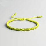 Bracelet tibétain porte-bonheur vert sur sol gris Kaosix