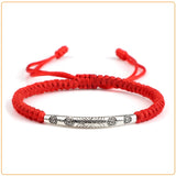 Bracelet tibétain rouge porte bonheur soleil sur fond blanc Kaosix