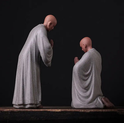 Deux Statues Moines Bouddhistes Humilité et Respect Debout Blanc Genoux Gris vue de dos sur fond noir Kaosix