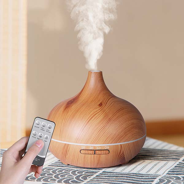 Diffuseur huiles essentielles 500 ml bois clair avec télécommande posé sur une table en bois Kaosix