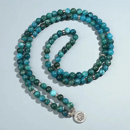 Mala 108 perles Apatite Bleue Symbole du Lotus sur sol gris kaosix