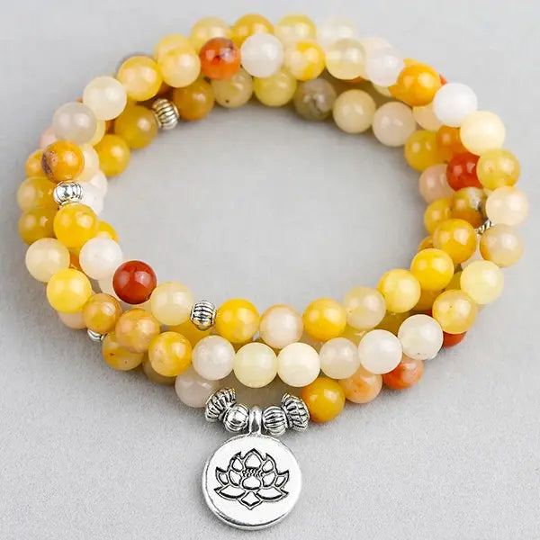 Mala 108 perles en Aventurine Jaune Lotus sur un sol gris kaosix