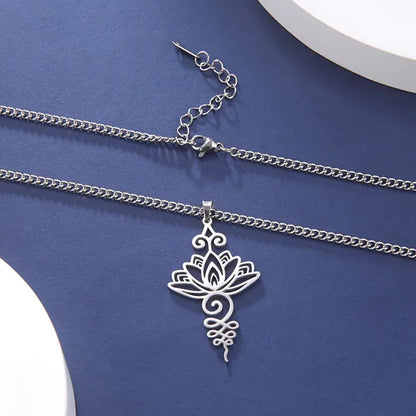 Pendentif Unalome Lotus Argent posé sur une nappe bleue Kaosix