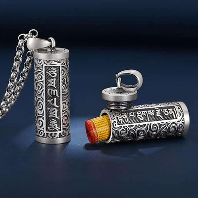 Pendentif porte-bonheur tibétain mantra Om avec les capuchon ouvert et un petit rouleau de papier qui sort de l'intérieur du pendentif Kaosix