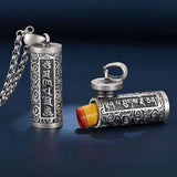 Pendentif porte-bonheur tibétain mantra Om avec les capuchon ouvert et un petit rouleau de papier qui sort de l'intérieur du pendentif Kaosix