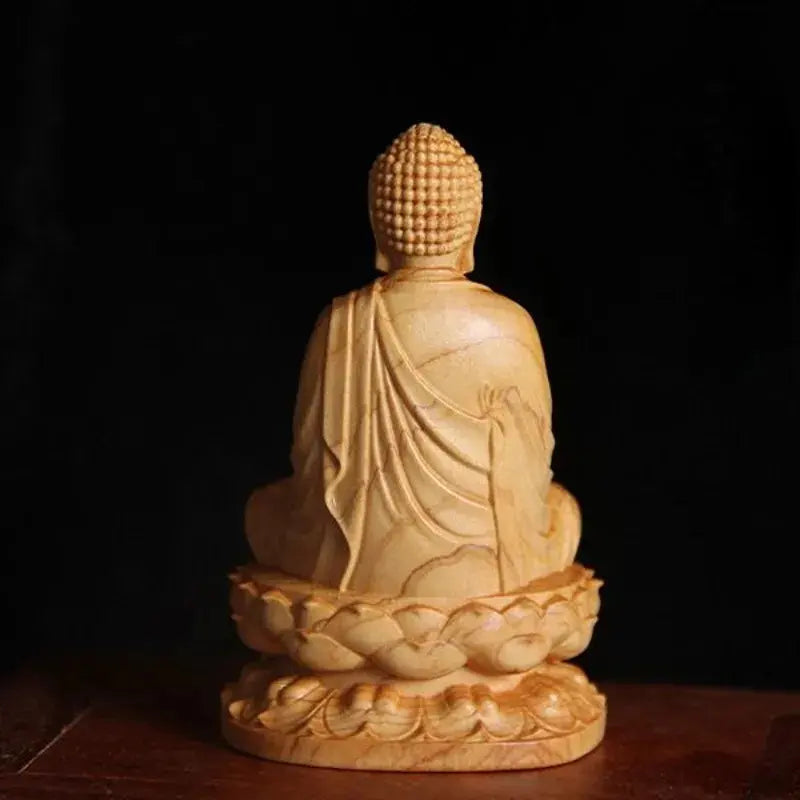 Statue Bouddha Assis Shakyamuni en Méditation sur une table en bois avec un fond noir et vue de dos kaosix