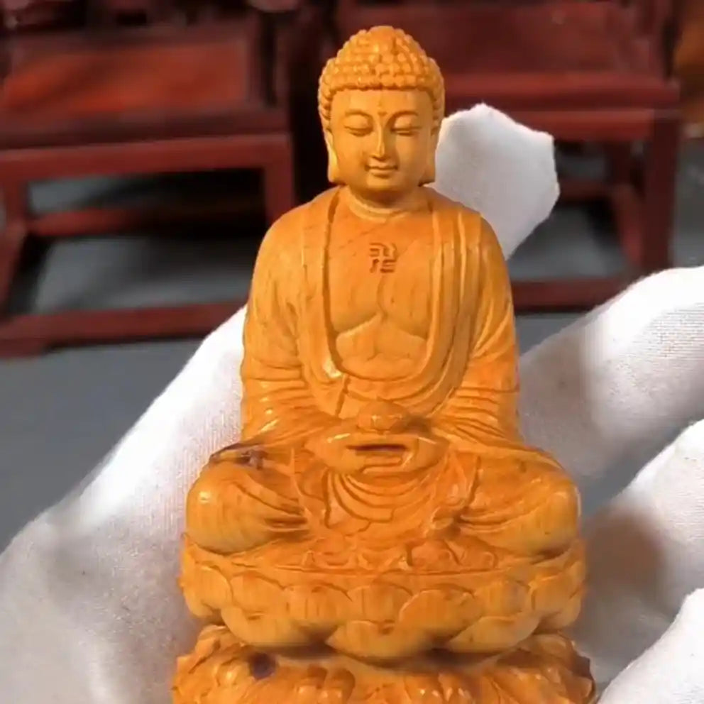 Statue Bouddha Assis Shakyamuni en Méditation sur une une main d'homme avec un gant blanc kaosix