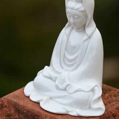 Statue Guanyin Déesse de la Compassion posé sur un socle métallique rouillé et vude de biais Kaosix