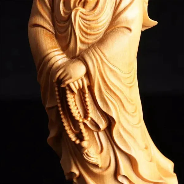 Statue Guanyin en bois de Cyprès Déesse de la Miséricorde sur fond noir gros plan sur les mains avec le mala Kaosix