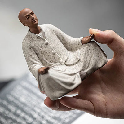 Statue Moine Bouddhiste Méditation tenue dans la main d'un homme kaosix