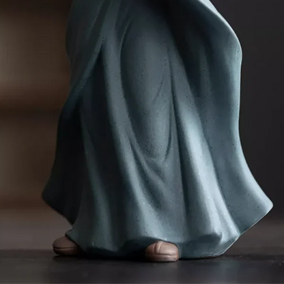 Statue Moine Bouddhiste Salutation gros plan sur les pieds et arrière plan sombre flou kaosix