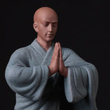 Statue Moine Bouddhiste Salutation gros plan sur le visage et arrière plan sombre flou kaosix