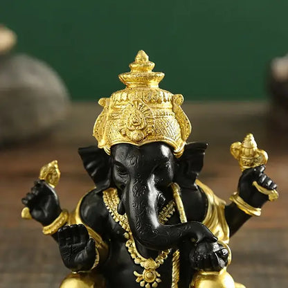 Statue de Ganesh doré sur table en bois vue de face gros plan sur la tête kaosix