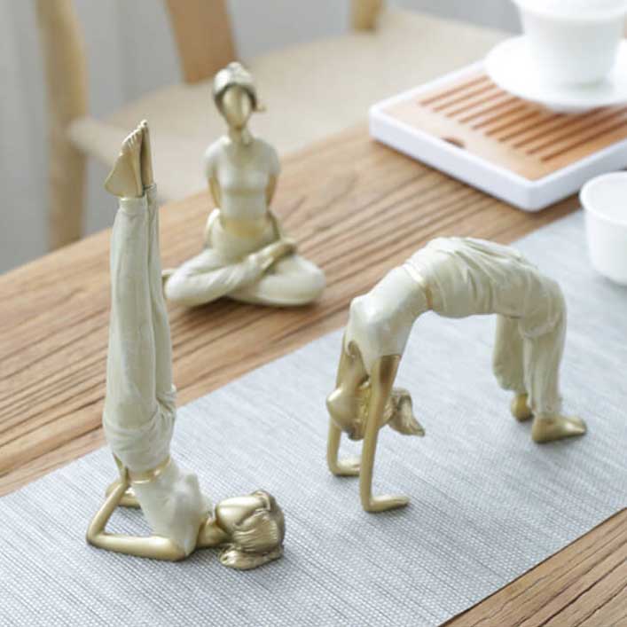 Statuettes de femmes en postures de yoga sur une table en bois 123 Kaosix