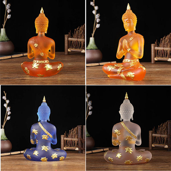 Trois Statuettes de Bouddha en résine translucide bleu orange blanc assises de face et de dos sur une table en bois et un fond noir Kaosix