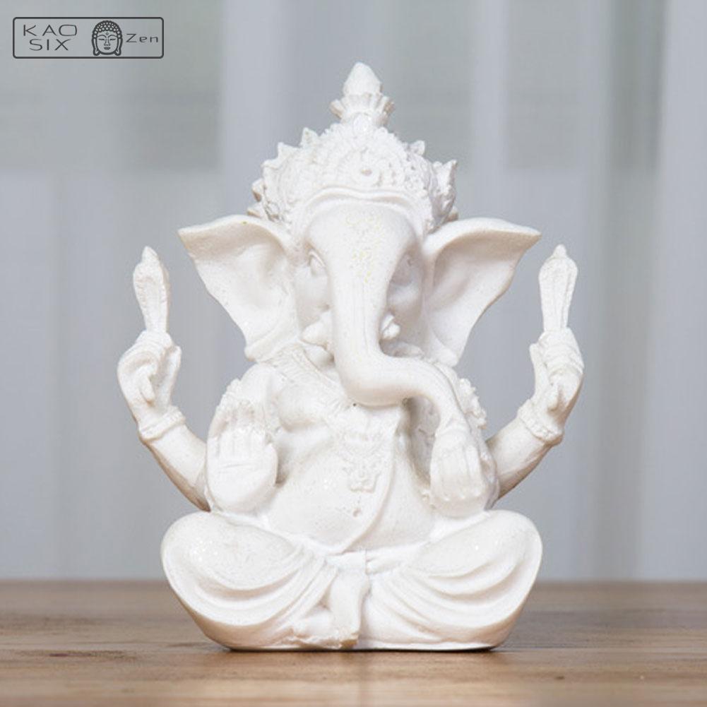 statue Ganesh blanche posé sur une table en bois kaosix