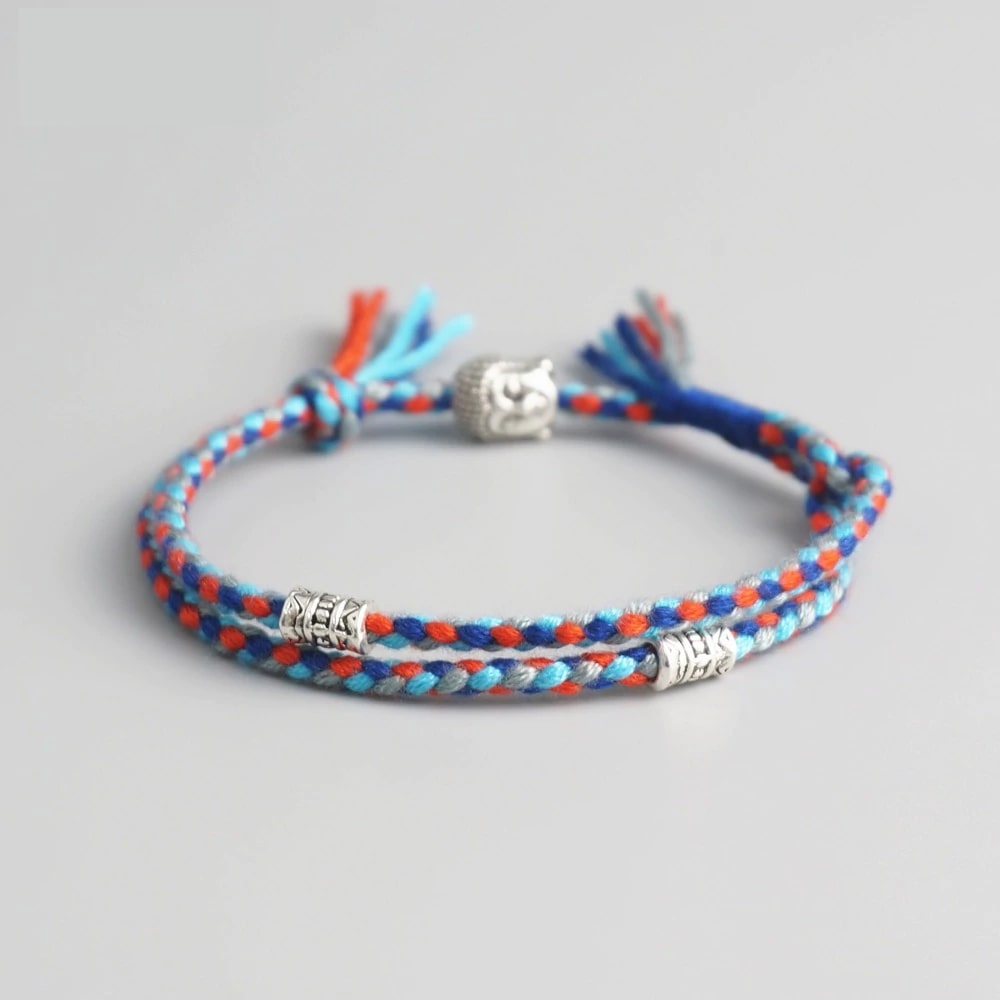 Bracelet Bouddha porte bonheur bleu et blanc tête de bouddha moulin à prières sur fond gris Kaosix