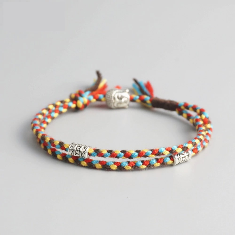 Bracelet Bouddha porte bonheur jaune et rouge tête de bouddha moulin à prières sur fond gris 1 Kaosix