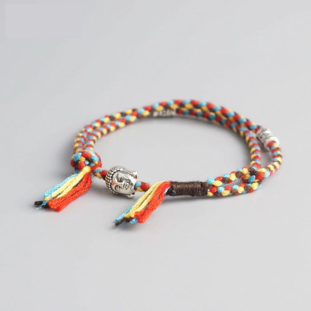 Bracelet Bouddha porte bonheur jaune et rouge tête de bouddha moulin à prières sur fond gris 3 Kaosix