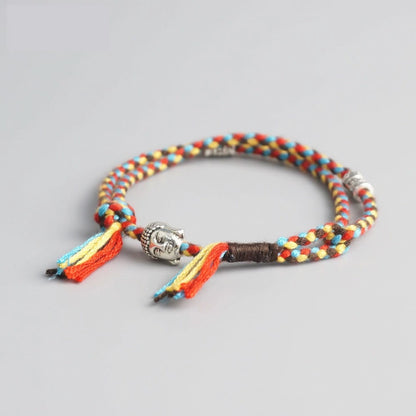Bracelet Bouddha porte bonheur jaune et rouge tête de bouddha moulin à prières sur fond gris 3 Kaosix