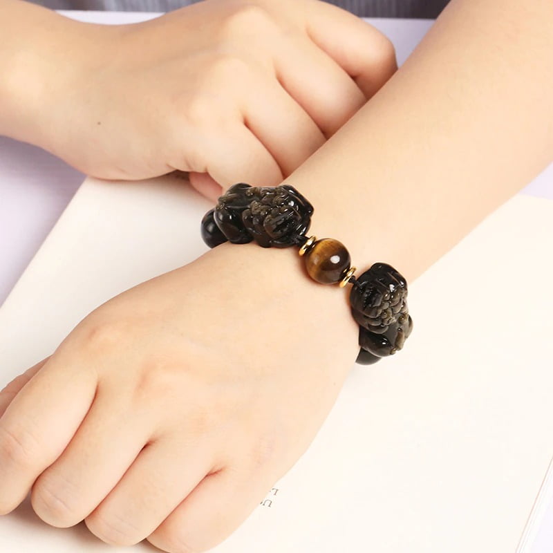 Bracelet Double Pi Xiu (Pi Yao) Obsidienne Dorée Œil de Tigre au poignet d'une jeune femme Kaosix