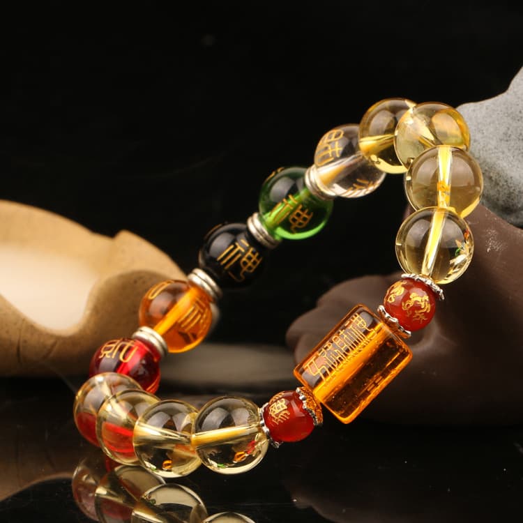 Bracelet Feng Shui Citrine Cinq Dieux et Cinq Éléments posé sur une pierre grise et fond noir Kaosix