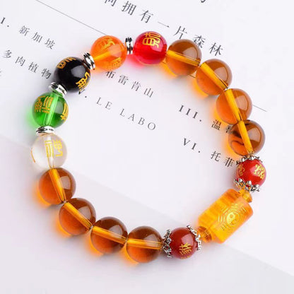 Bracelet Feng Shui Citrine Cinq Dieux et Cinq Éléments posé sur un livre blanc Kaosix