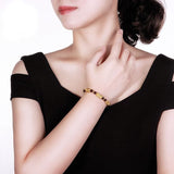 Bracelet Pi Xiu Grenat Rouge au poignet d'une femme qui porte une robe noire Kaosix