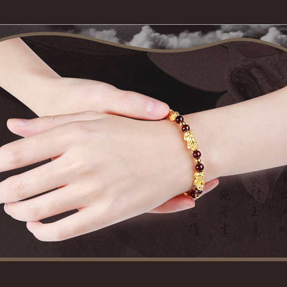 Bracelet Pi Xiu Grenat Rouge au poignet d'une femme vue gros plan Kaosix