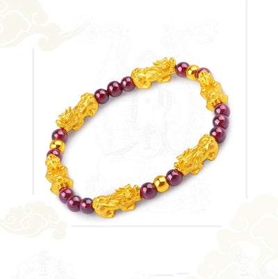 Bracelet Pi Xiu Grenat Rouge sur un sol blanc avec un fond blanc Kaosix