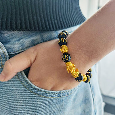 Bracelet Pi Xiu Or en obsidienne noire sur poignet d'homme Kaosix