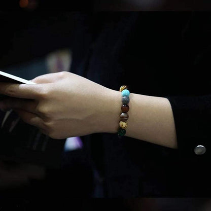 Bracelet Système Solaire avec 11 Planètes en Perles de Pierres au poignet d'une femme en noir Kaosix