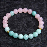 Bracelet “confiance” en quartz rose et amazonite sur une surface grise Kaosix