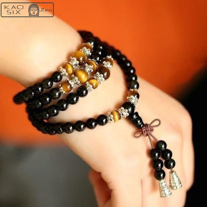 bracelet mala 108 perles onyx noir œil de tigre enroulé sur un poignet de femme