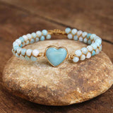 Bracelet amazonite femme cœur posé sur une pierre Kaosix