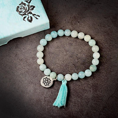 Bracelet amazonite verte symbole lotus sur un sol en ciment sombre Kaosix