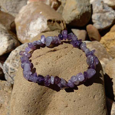 Bracelet baroque (chips) améthyste posé sur un rocher Kaosix