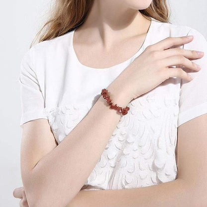 Bracelet baroque (chips) grès rouge au poignet d'une jeune fille habillée de blanc Kaosix