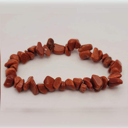 Bracelet baroque (chips) grès rouge posé sur un sol gris Kaosix