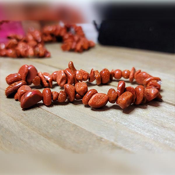 Bracelet baroque (chips) grès rouge sur une table en bois Kaosix